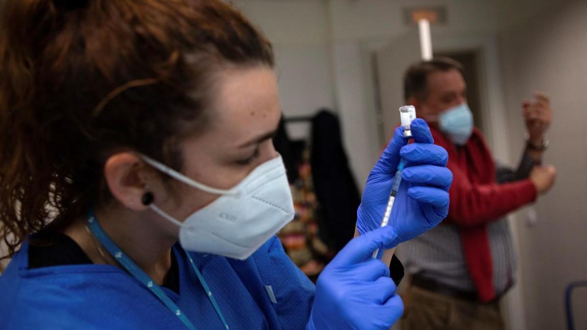 Una enfermera prepara la jeringuilla durante el proceso de administración de la vacuna de Pfizer