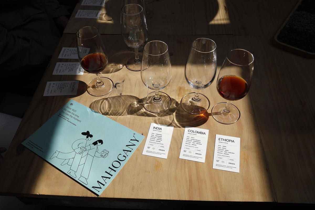 Copes amb cafè de Mahogany i targetes identificatives del seu origen.