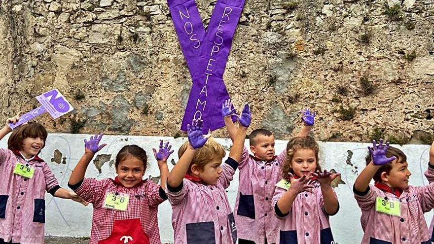 Los niños del Corazón de María muestran sus manos pintadas de morado. 