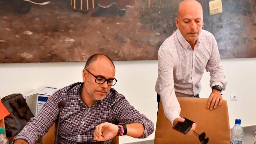 Roberto Ramírez, concejal de Nueva Canarias, mira el reloj mientras Julio Ojeda, candidato socialista, se sienta en el pleno de Santa Lucía de este miercoles.