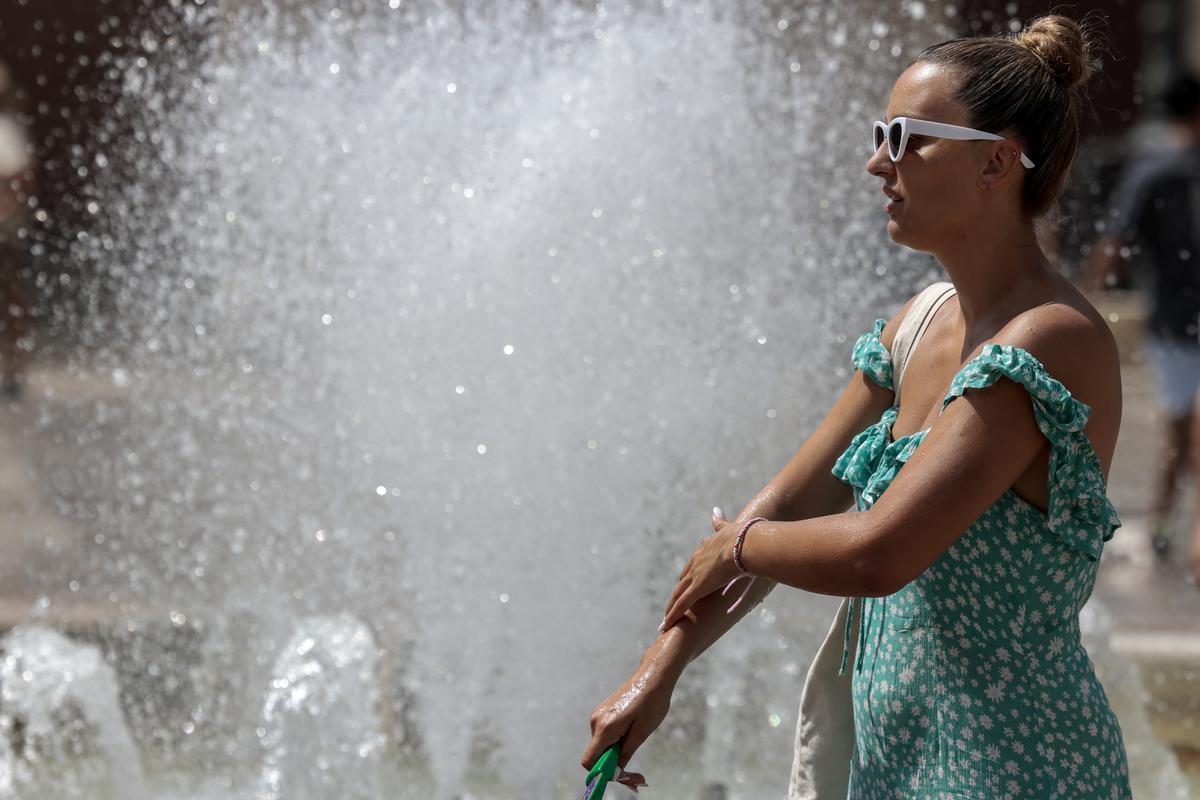 Una turista se refresca en una fuente en València.