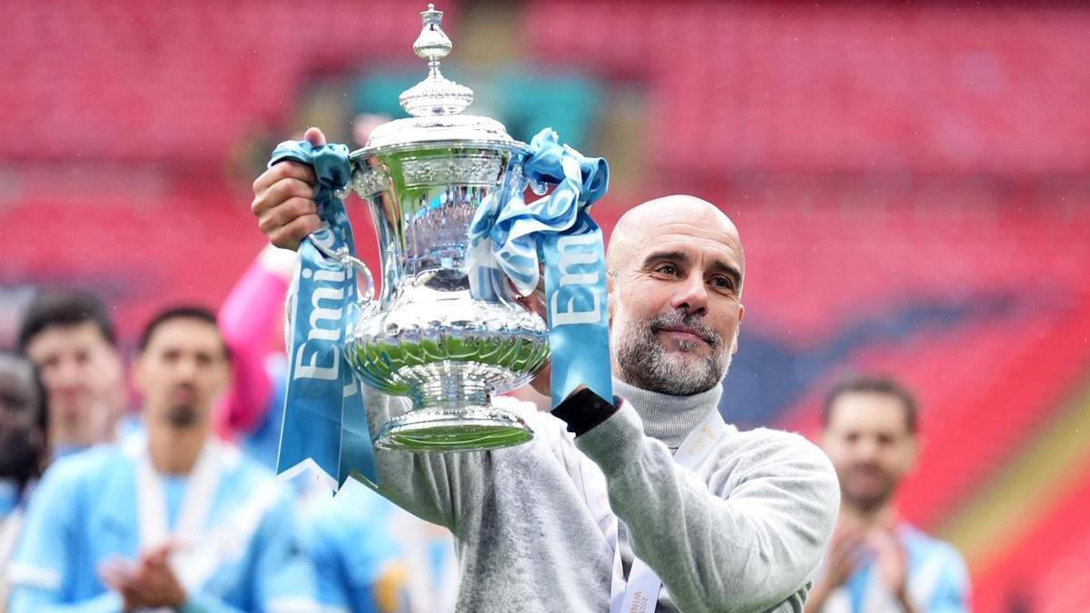 El entrenador del Manchester City, Pep Guardiola, celebra con el trofeo de la FA Cup tras la final de la FA Cup inglesa entre el Chelsea y el Manchester City en el estadio de Wembley.