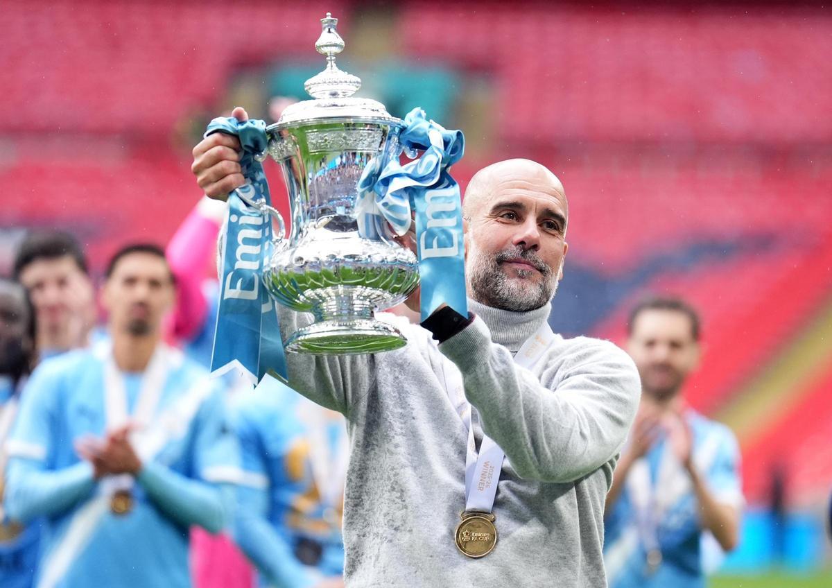 El entrenador del Manchester City, Pep Guardiola, celebra con el trofeo de la FA Cup tras la final de la FA Cup inglesa entre el Chelsea y el Manchester City en el estadio de Wembley.