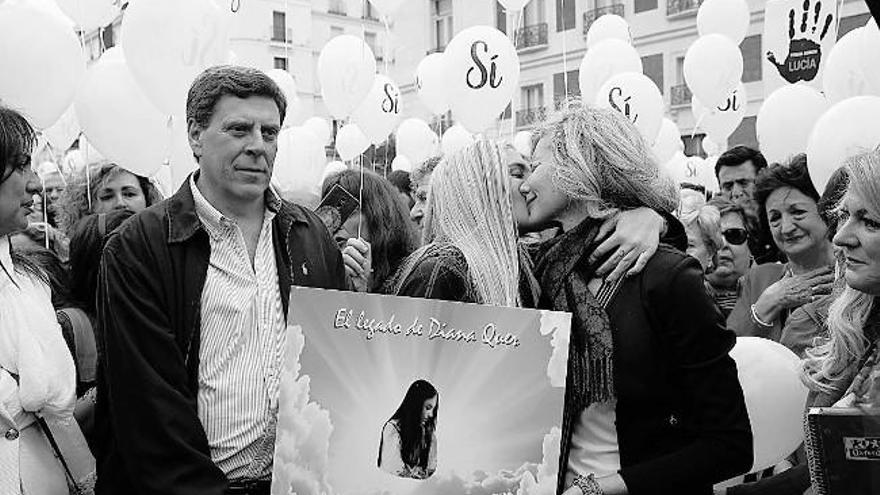 Los padres y hermana de Diana Quer, con la foto de su hija, en la manifestación en Madrid.  // Efe