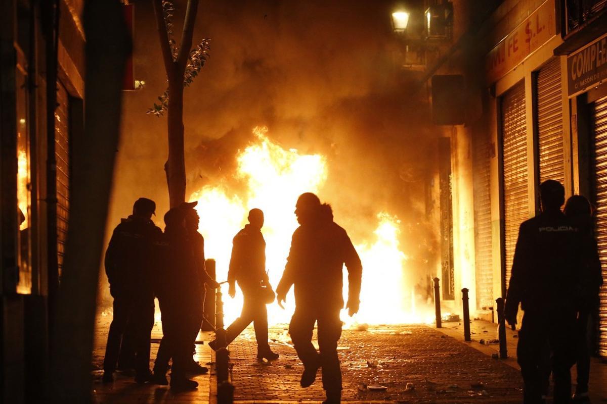 GRAF3258  MADRID  15 03 2018 - Contenedores incendiados en la calle Meson de Paredes con la calle del Oso  en el barrio de Lavapies de Madrid  tras la muerte de un mantero de un paro cardiaco durante un control policial contra el top manta en el barrio de Lavapies de Madrid  Tras el suceso  se han concentrado decenas de personas en protesta contra la presion policial que existe en la zona contra los vendedores del top manta  EFE JAVIER LIZON