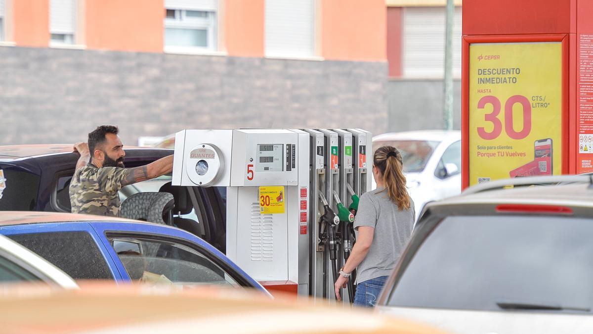 Varios conductores repostan sus vehículos en una gasolinera.