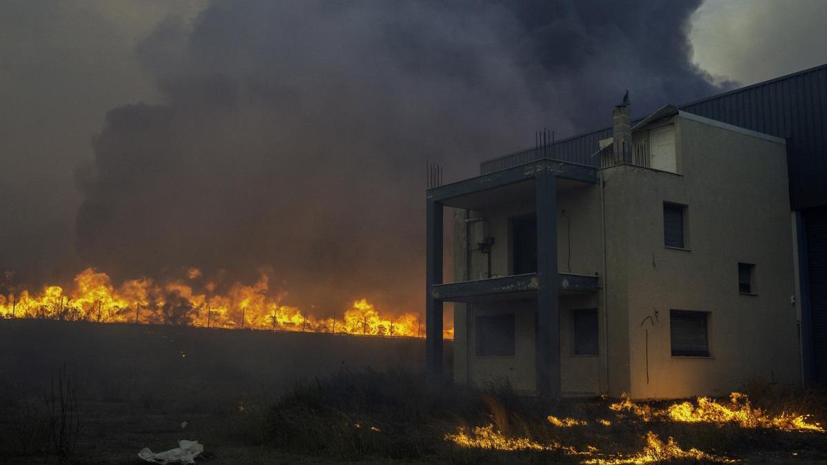 Casa rodeada de llamas en uno de los incendios de Grecia.