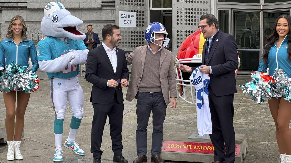 El alcalde de Madrid, José Luis Martínez-Almeida (c) visita la exposición de cascos conmemorativos con motivo de la celebración por primera vez en España de un encuentro oficial de la temporada regular de la NFL entre los Miami Dolphins y los Washington Commanders.