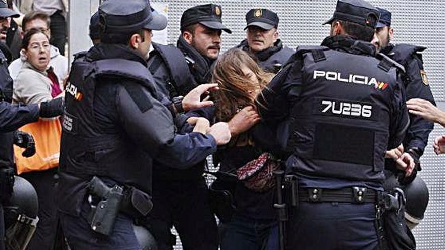 Tres policies, amb una manifestant, durant el referèndum de l&#039;1 d&#039;octubre a Girona.