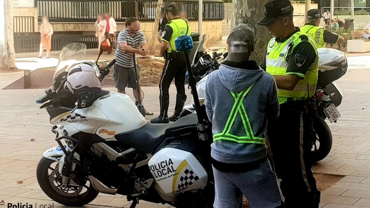 Un policía local habla con el conductor de un patinete eléctrico en Palma.