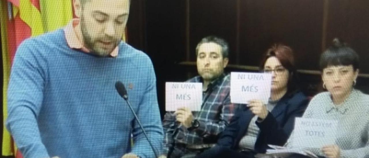 Ediles del PSOE, con carteles, durante la intervención del concejal de Vox.