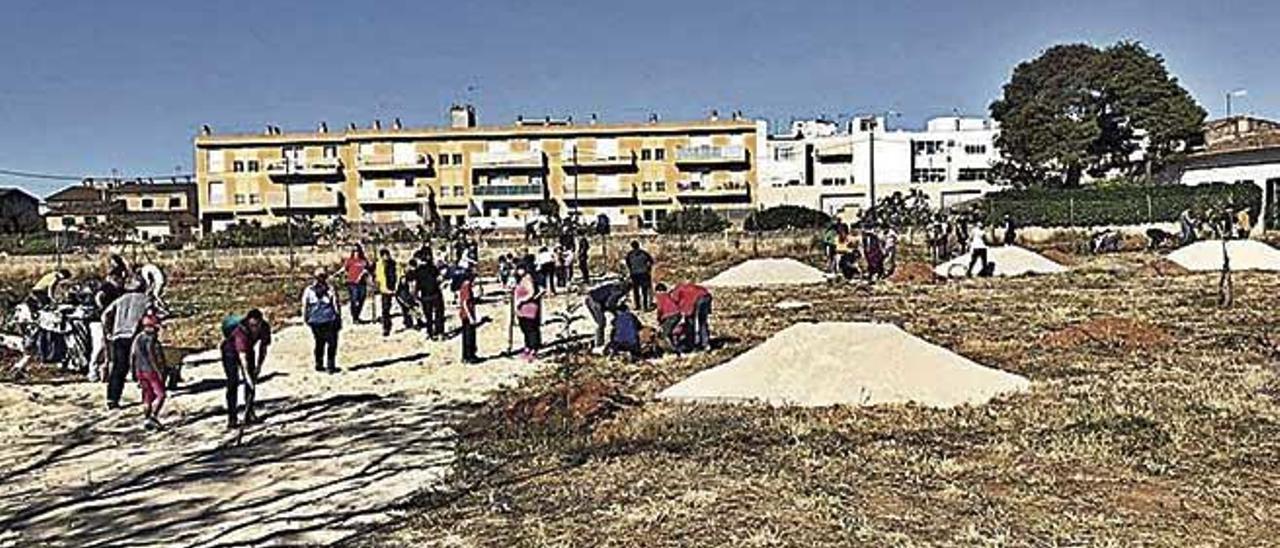 NiÃ±os y monitores acondicionan el solar para la zona de acampada.