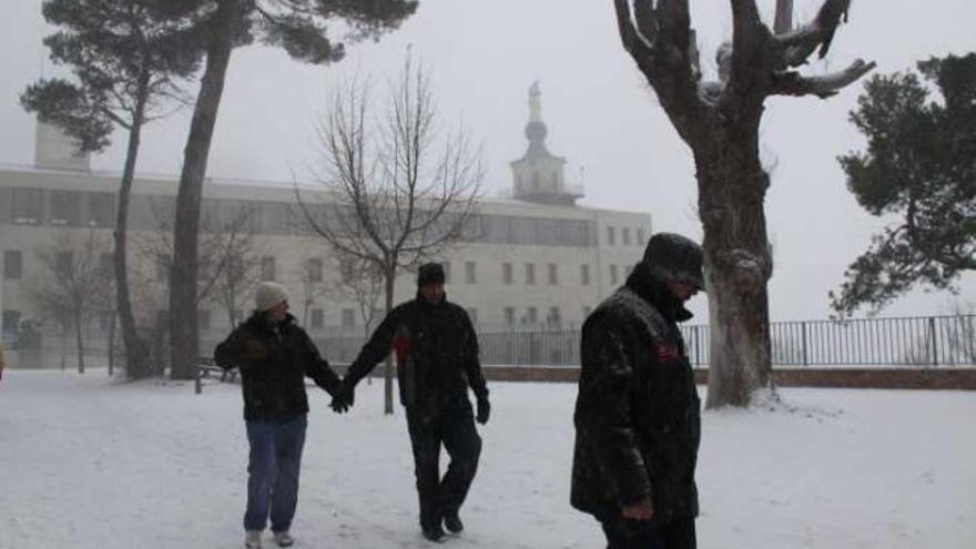 Tres personas disfrutan de la nieve junto a la Font Roja.