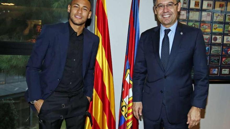 Neymar posa con Bartomeu tras firmar la renovación de su contrato. // Efe