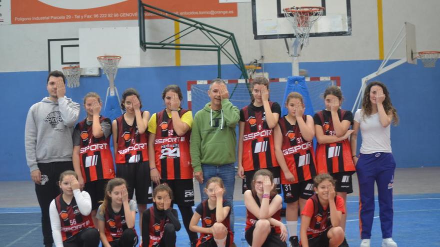 Jugadoras y técnicos de un equipo femenino del CB Genovés haciendo el gesto de la campaña