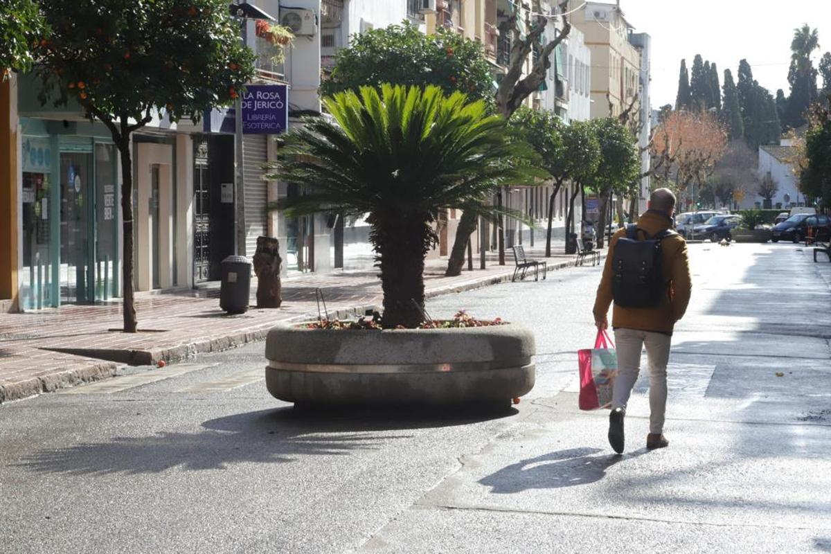 Un peatón camina por el centro de la avenida de La Viñuela.