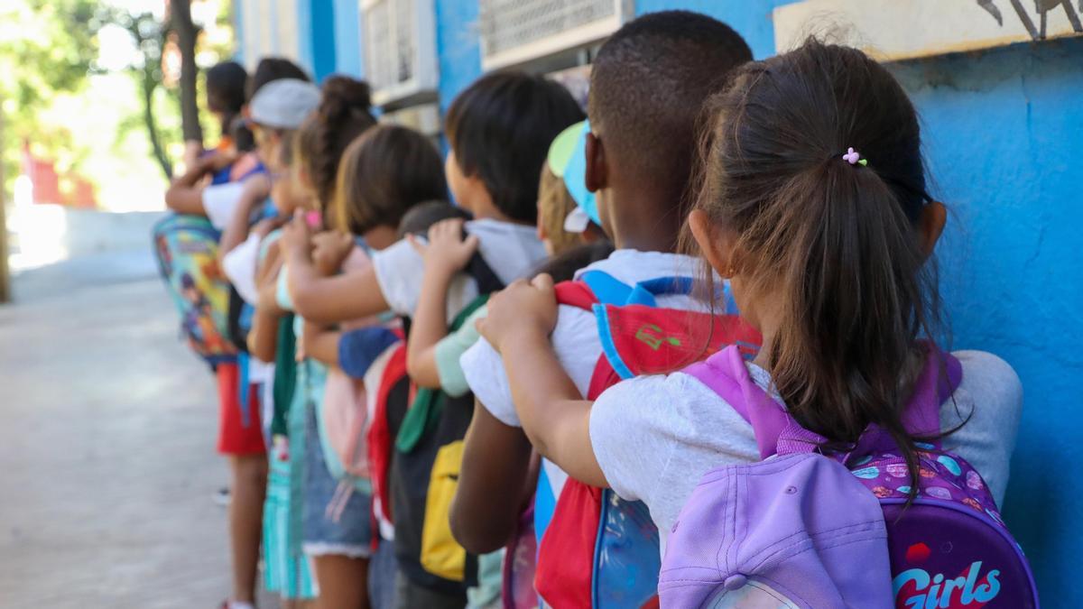 Archivo - Varios niños hacen fila con sus mochilas en una imagen de archivo