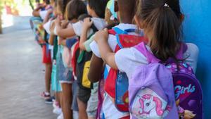 Archivo - Varios niños hacen fila con sus mochilas en una imagen de archivo