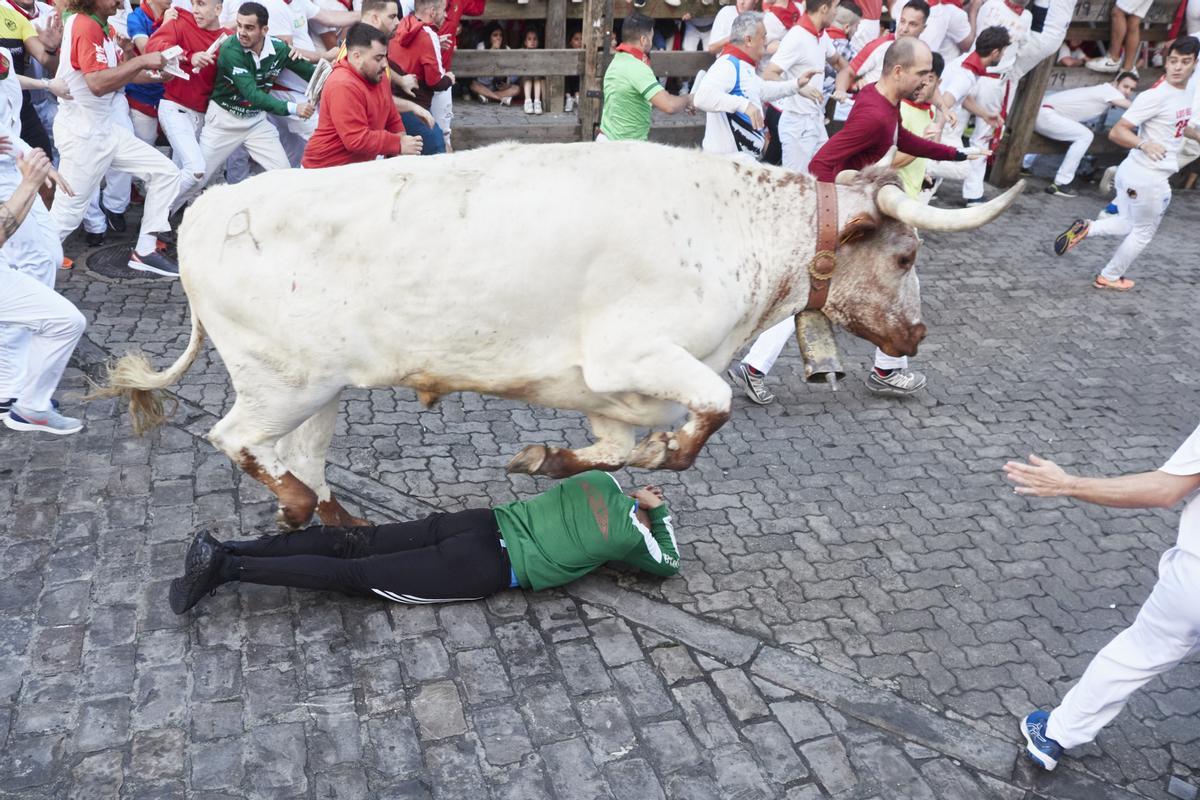 Un toro salta encima de un corredor durante el primer encierro de las Fiestas de San Fermín 2022 de la ganadería de Núñez de Cuvillo, en Pamplona, Navarra.