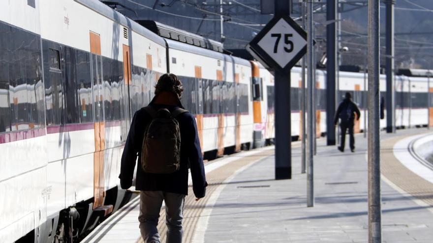 Imatge d&#039;arxiu de dos usuaris de la línia R4 de Renfe just abans de pujar al tren a Manresa en direcció a Sant Vicenç de Castellet