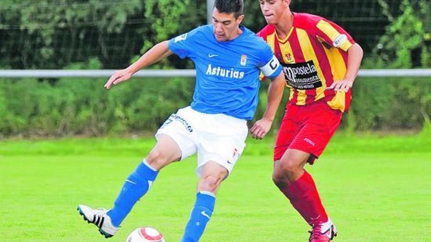 El capitán del Oviedo protege el balón ante el acoso de un jugador del Conxo.