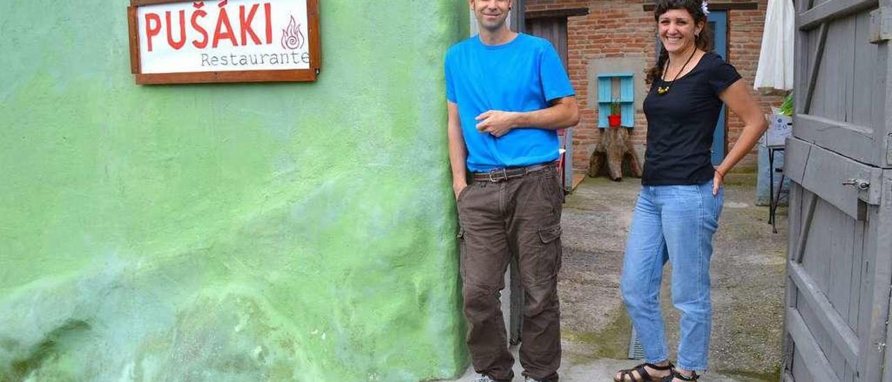 Patricio y Sara, a la entrada del establecimiento que han reabierto en el pueblo de La Puerta, en Cabranes.