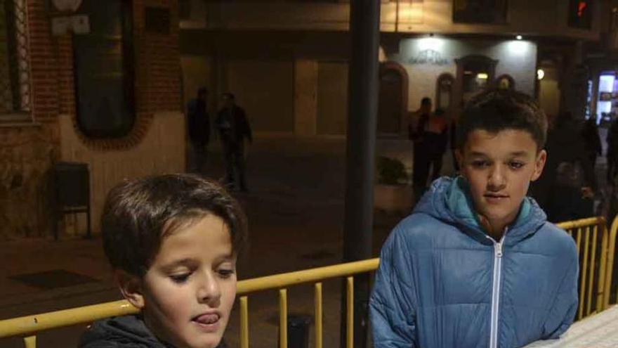 Dos niños cogen chocolate ayer por la tarde para combatir el frío y la niebla.