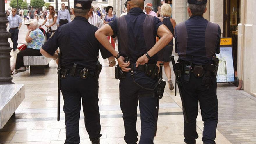 Tres agentes patrullan por la calle Larios.