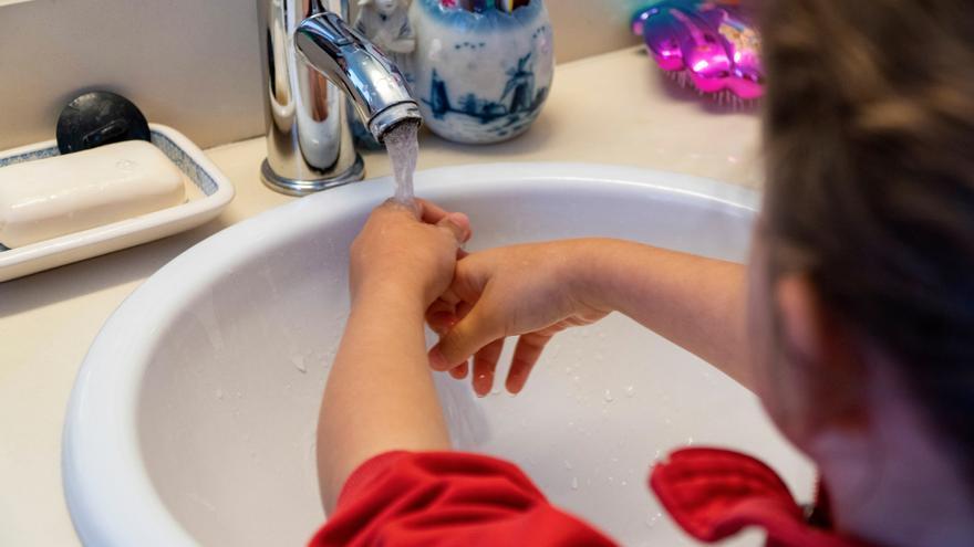 Una mujer se lava las manos para evitar infecciones.