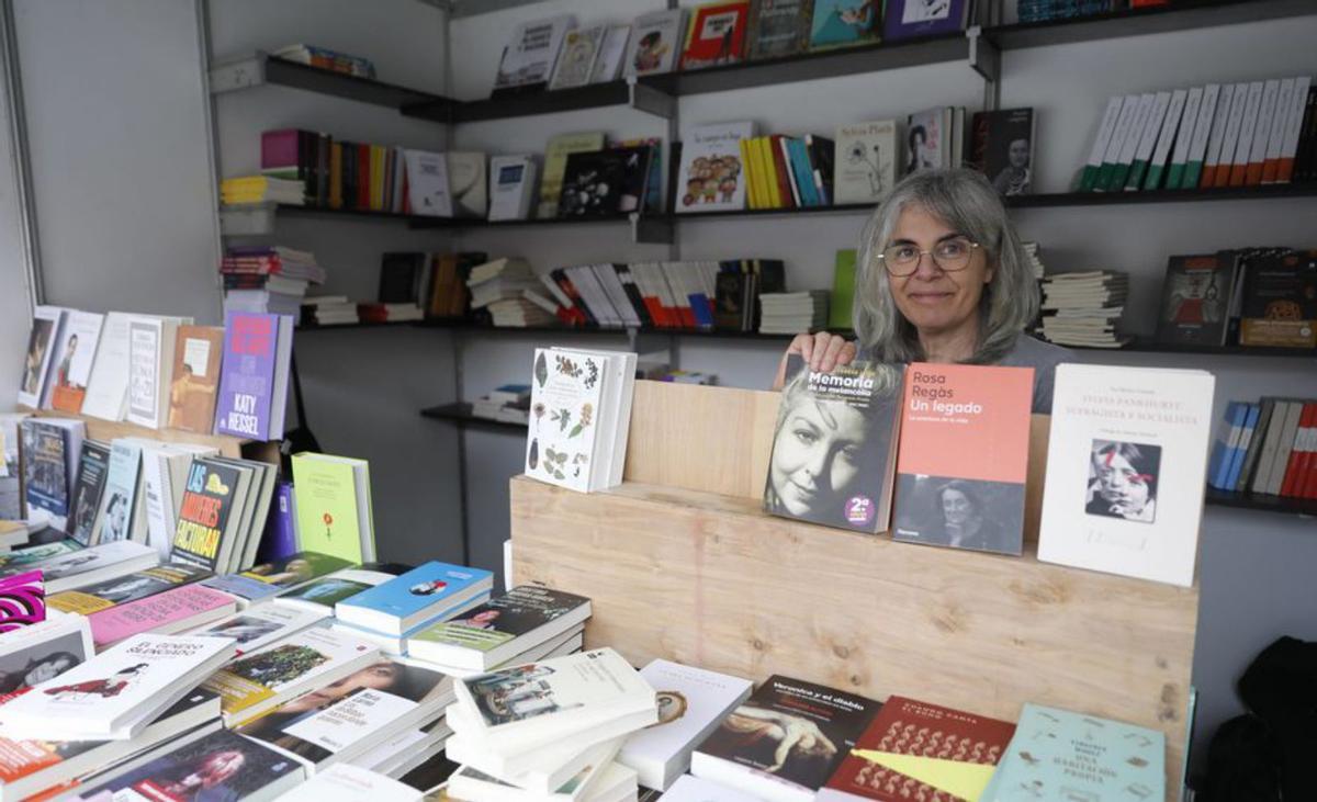 Elena Lerma, colocando libros en la caseta de la librería Atenea, en la calle Francisco Tomás y Valiente. | Marcos León