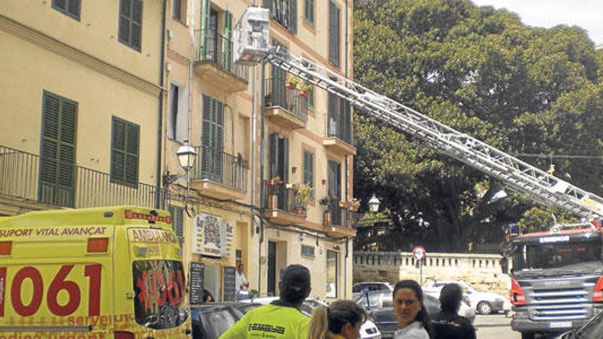 Policías y bomberos auxilian a un joven en apuros en un piso en el centro de Palma