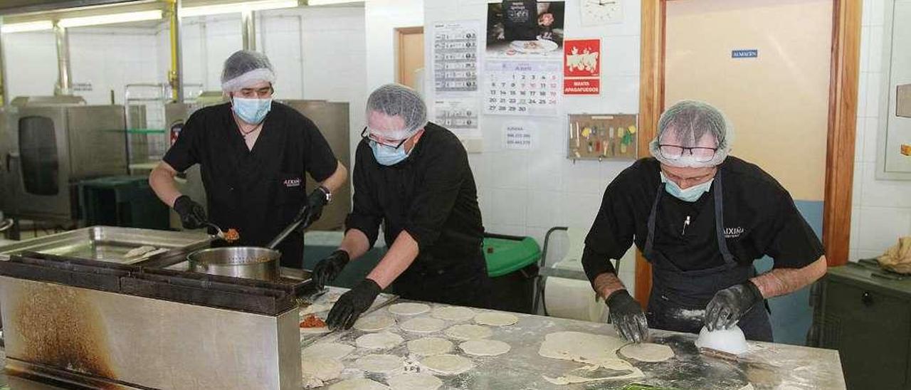 Trabajadores del servicio de restauración de Aixiña elaboran empanadillas para los menús a domicilio. // Iñaki Osorio