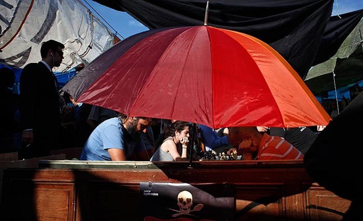 Uns joves juguen aquest dijous a escacs a l’acampada de Puerta del Sol.