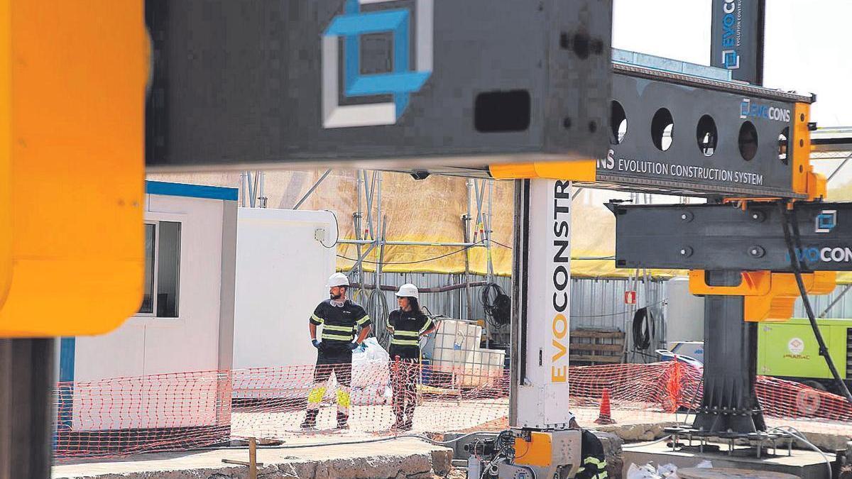 Operarios junto a una impresora 3D para la construcción de edificios.