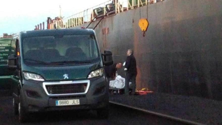 Trabajadores de la funeraria, junto al pesquero que atracó en El Musel para desembarcar el cadáver de uno de sus tripulantes.