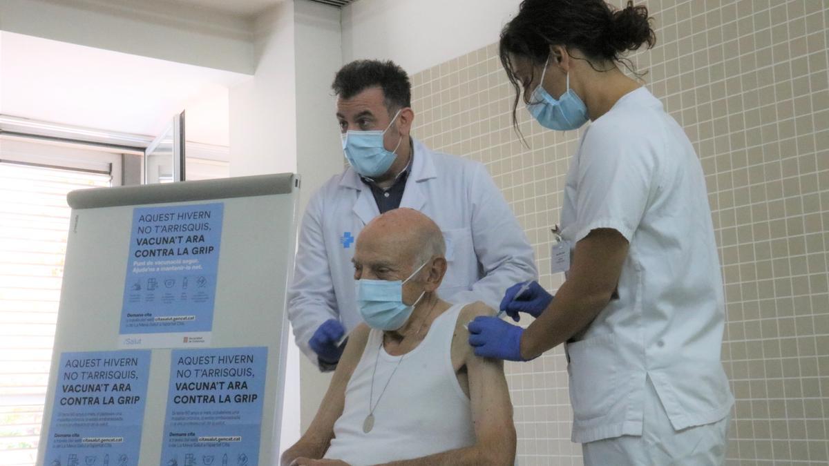 Una persona d&#039;edat avançant reben la vacuna contra la grip i la tercera dosi de la vacuna contra la covid al CAP Rio de Janeiro de Barcelona