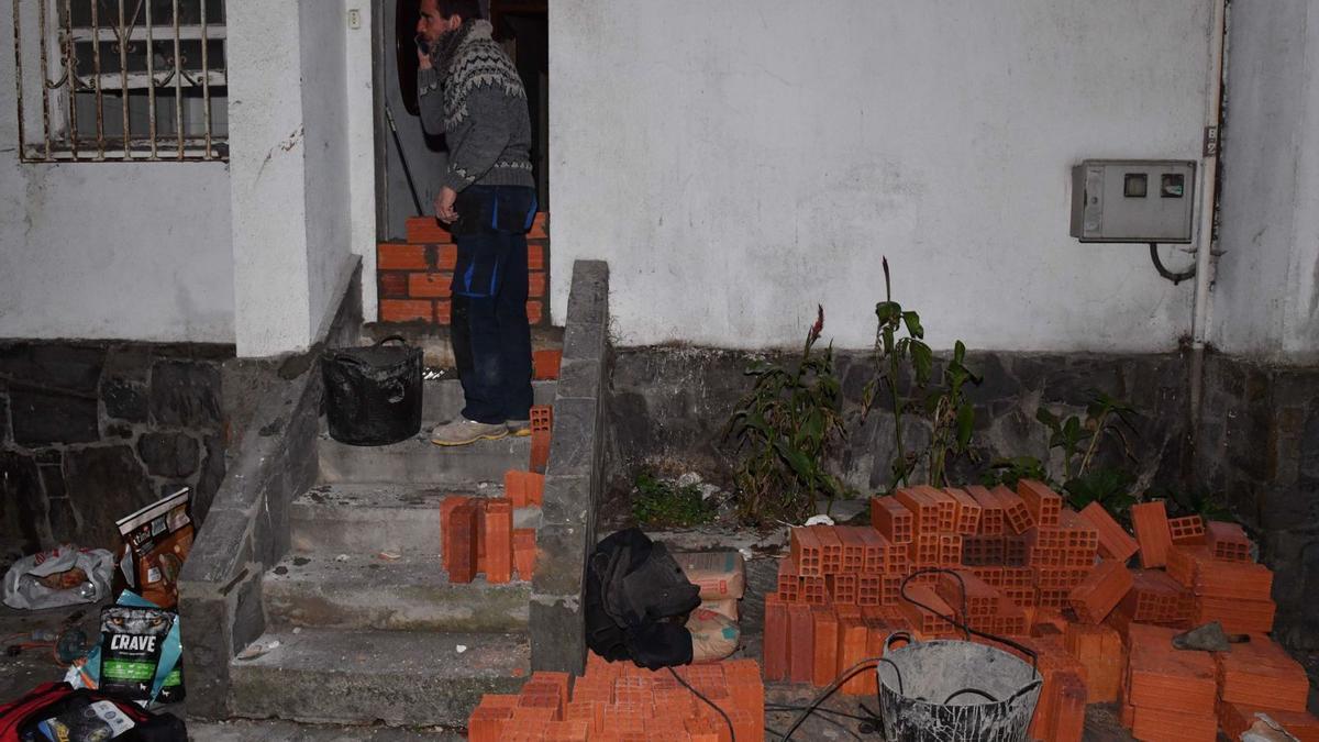 Un trabajador tapia la entrada de una casa del Barrio de las Flores, desalojada por la presión de los propios vecinos.  | // VÍCTOR ECHAVE