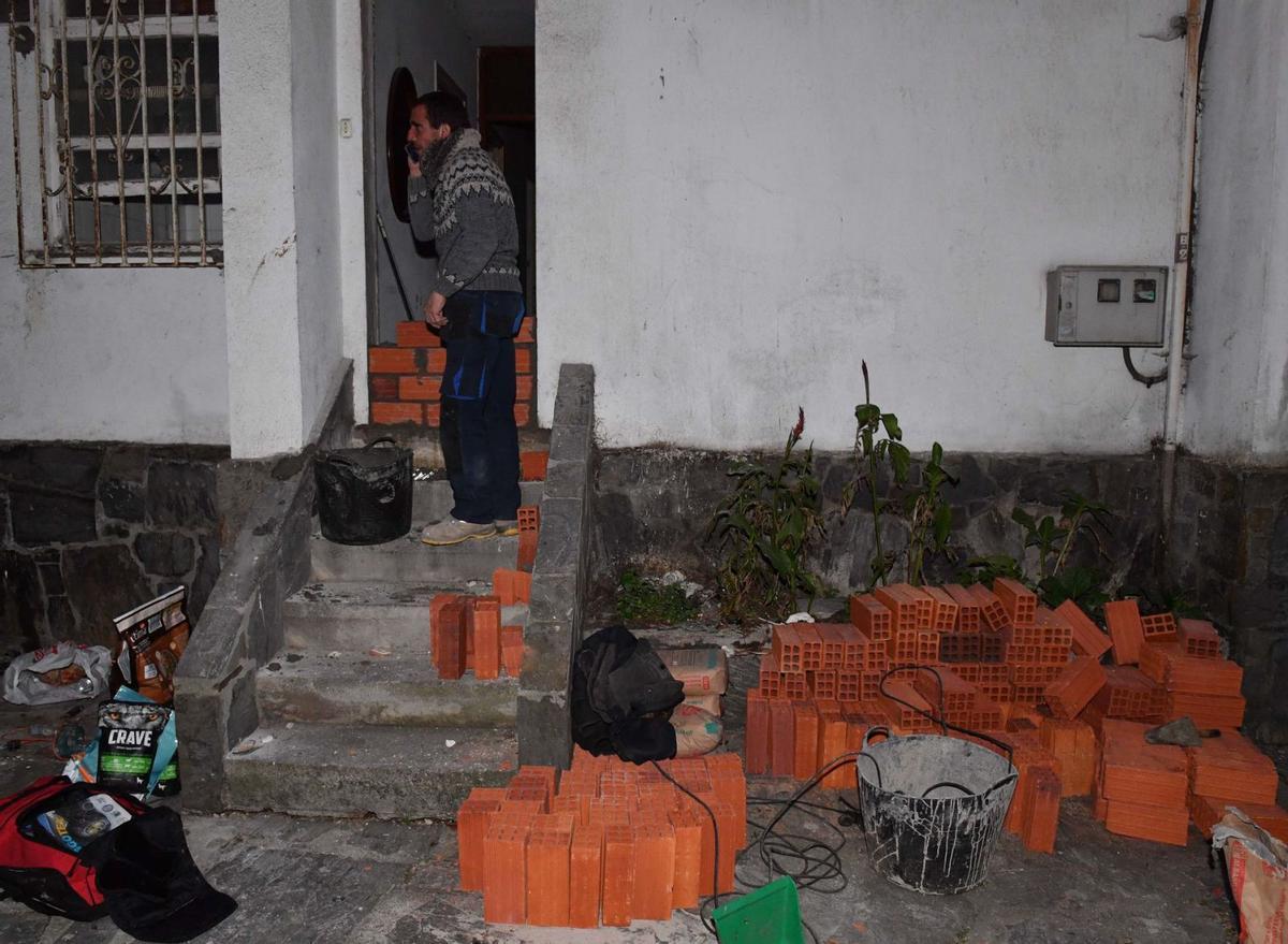 Un trabajador tapia la entrada de una casa del Barrio de las Flores, desalojada por la presión de los propios vecinos. | // VÍCTOR ECHAVE