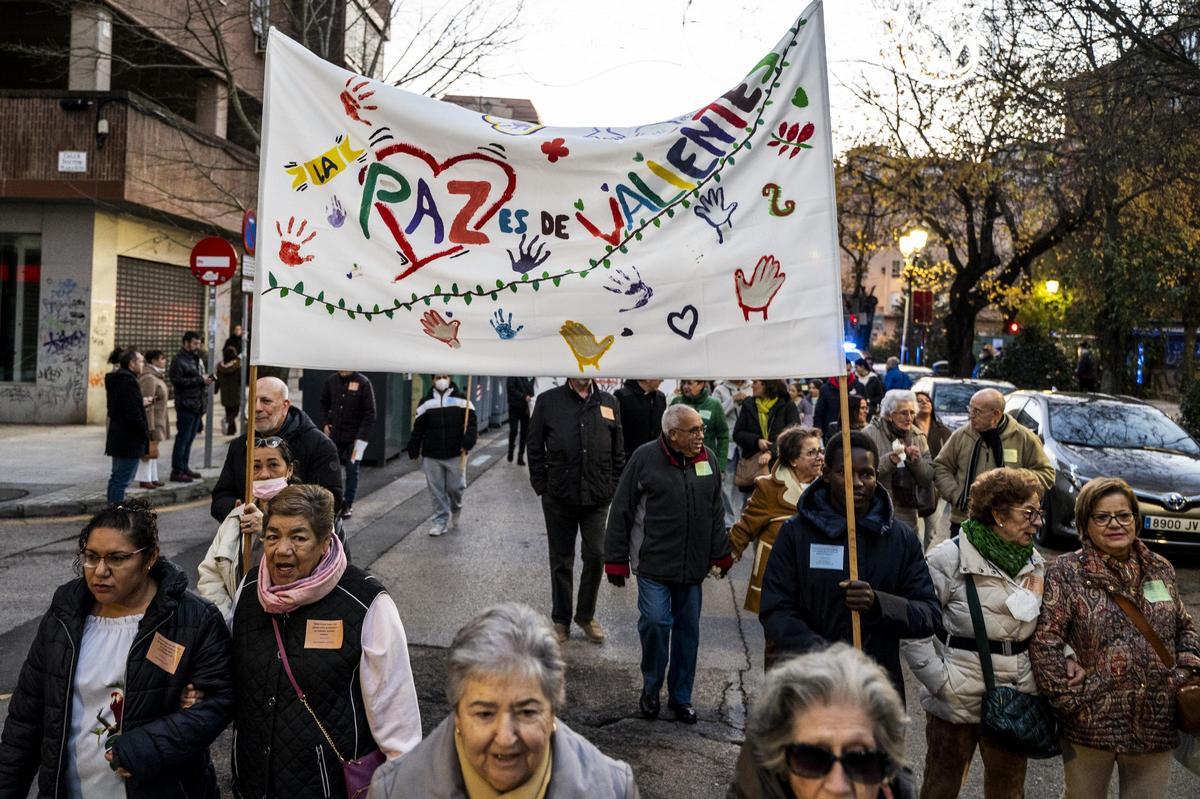 Participantes de la marcha portan pancartas con mensajes a favor de la paz y la convivencia.