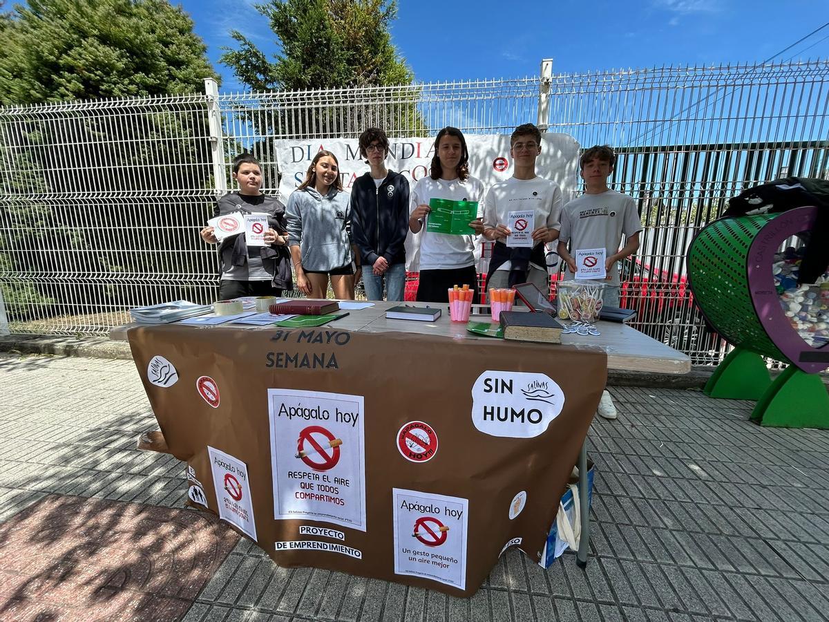 Parte del alumnado que participa en la campaña, en el puesto informativo frente al colegio de Salinas.