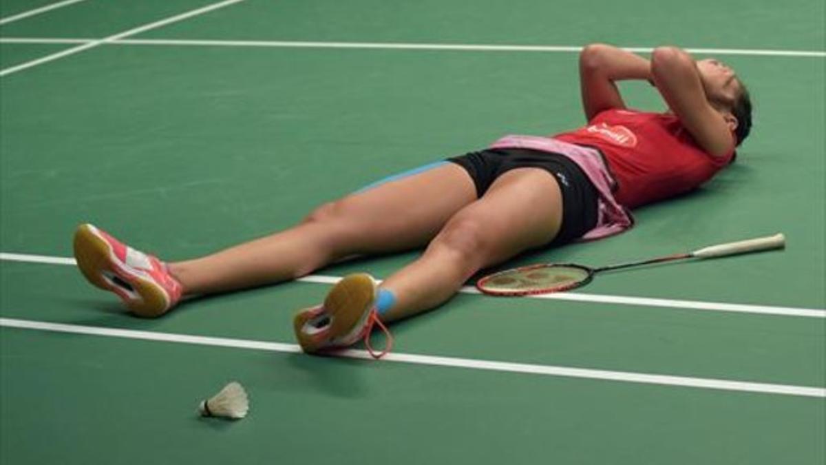 Carolina Marín celebra su majestuoso triunfo lanzándose a la pista con las manos en la cara después de lograr el título mundial, ayer en Yakarta.