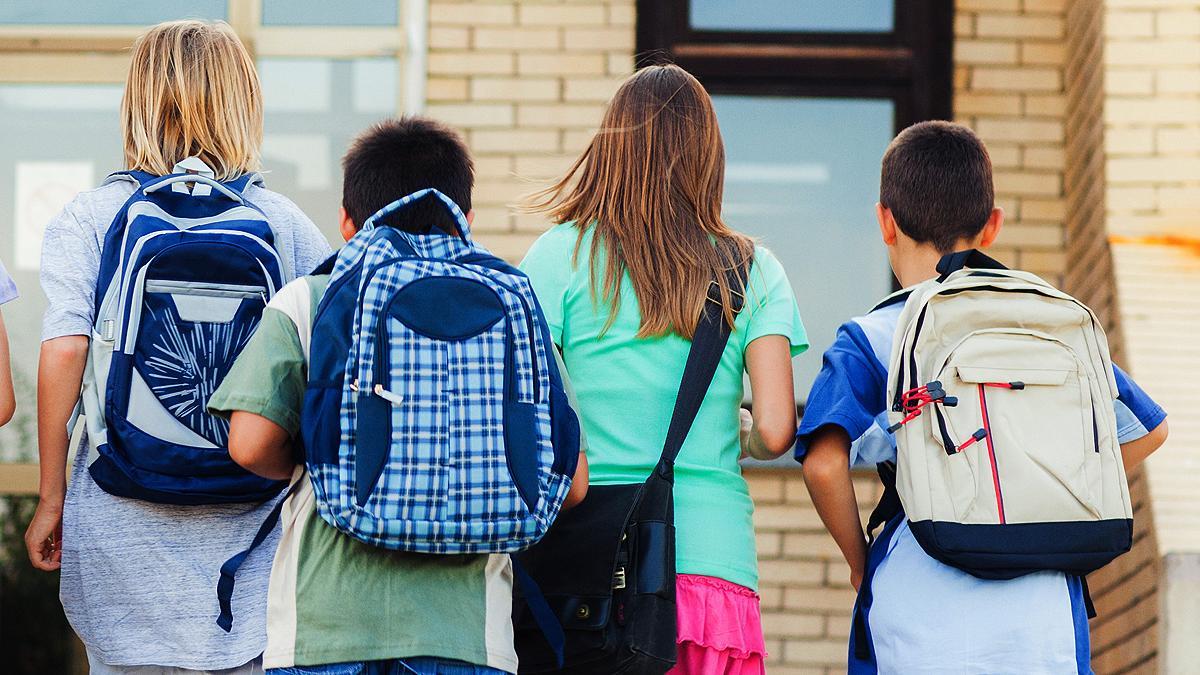 Varios escolares camino del colegio.