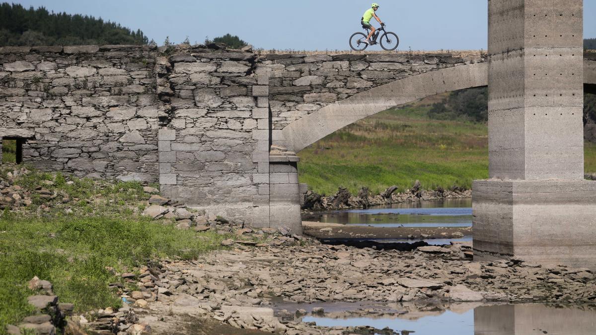 Un ciclista pasa por encima del viejo puente sobre el Miño en Lugo, sepultado por las aguas en 1962 y visible cuando el cauce transcurre muy bajo.