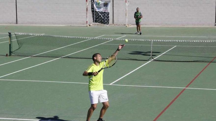 Pablo León sirve en la final de Veteranos +35 que disputó ante Jorge González (al fondo). // Santos Álvarez