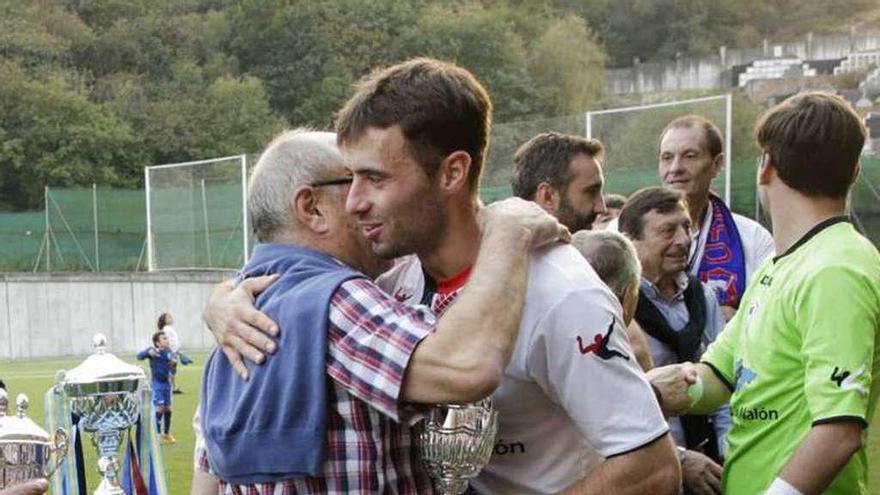 Álvaro Cuello recibe el trofeo de campeón de manos de Luis Gallego tras el partido disputado en El Bayu.