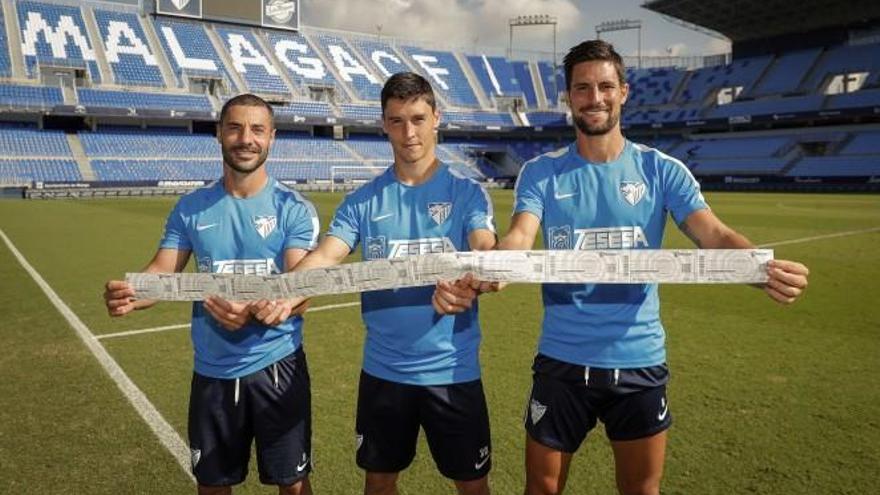 Los capitanes del Málaga CF posan con una tira de entradas del partido contra el Numancia