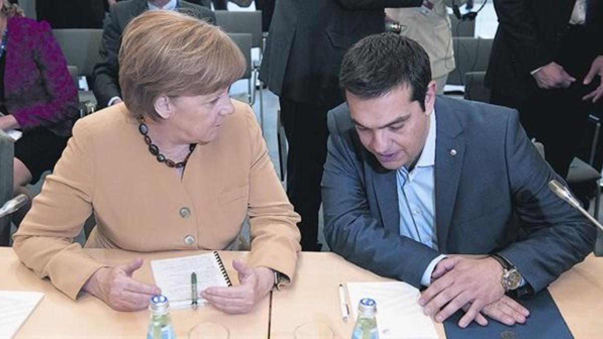 La cancillera alemana Angela Merkel con el primer ministro griego, Alexis Tsipras, ayer en Riga.