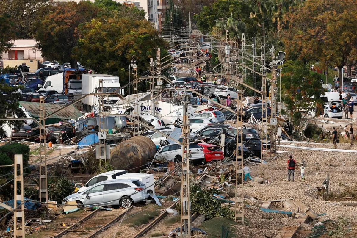 Vehículos amontonados sobre las vías del tren en Alfafar (Valencia) tras el paso de una devastadora DANA.