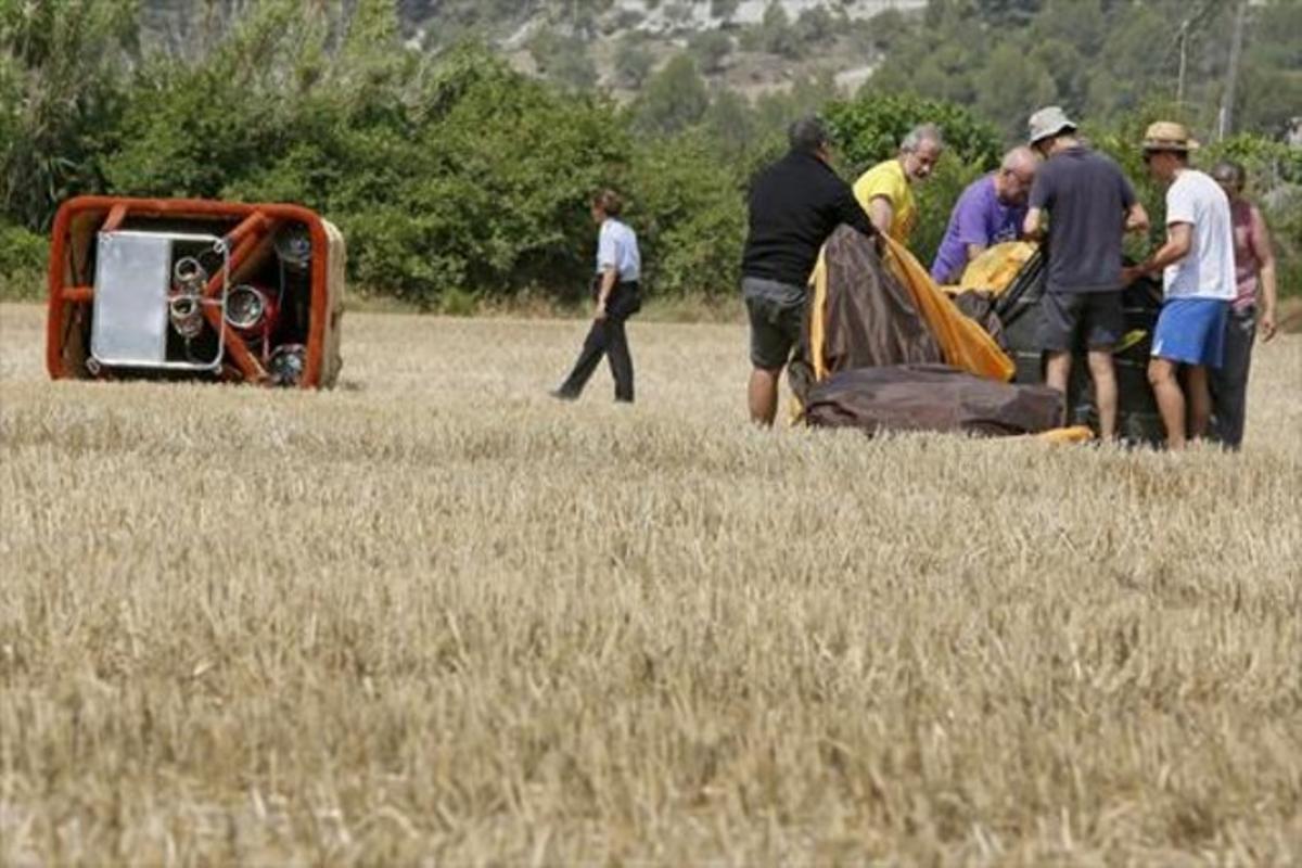 Membres de l’organització del festival recullen el globus sinistrat a la zona de Can Titó, al municipi de Vilanova del Camí.