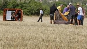Membres de l’organització del festival recullen el globus sinistrat a la zona de Can Titó, al municipi de Vilanova del Camí.